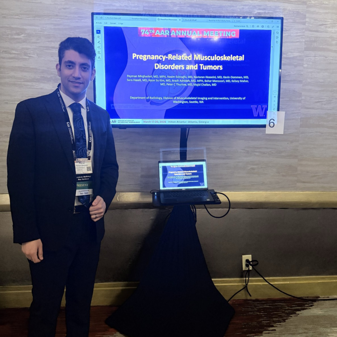 Dr. Peyman Mirghaderi poses before his poster presentation at the AAR Annual Meeting.