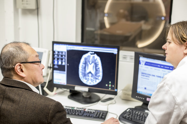 Two people in MRI control room.