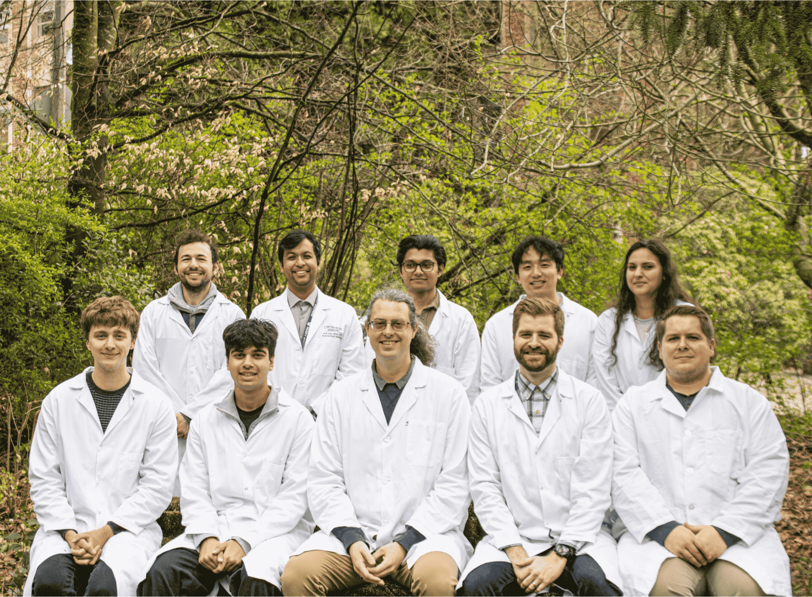 Members of the SAIL Lab team pose for a photo in a forest setting.
