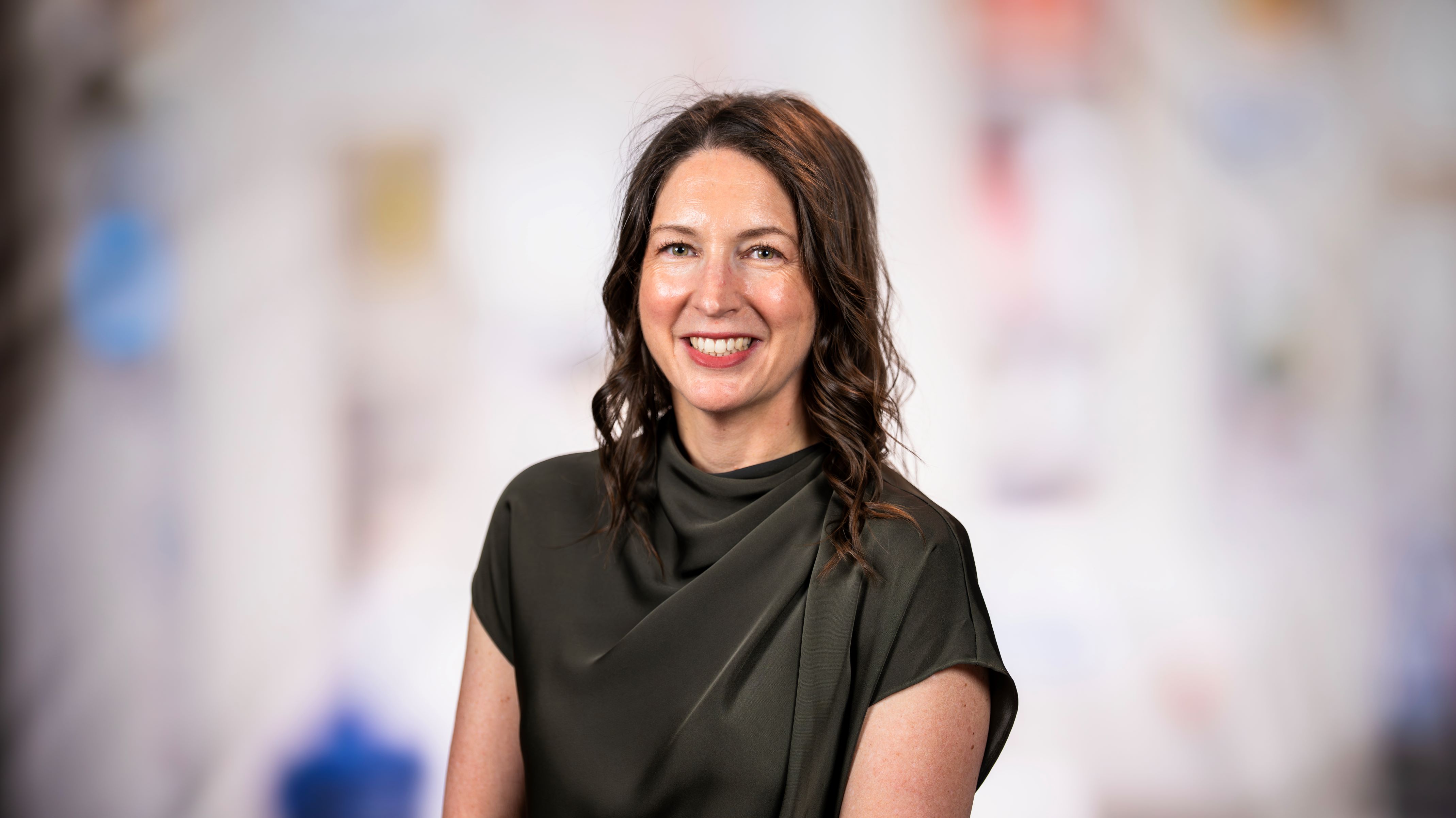 Dr. Kohr smiles at the camera. she has long brown hair and black satiny blouse